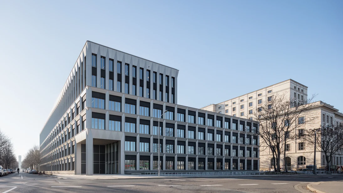 Die Fassade mit hoher Anzahl an Fenstern in einer regelmäßigen Rasterstruktur lässt viel Tageslicht ins Innere. Die Struktur wird durch große Metallelemente hergestellt, welche die Öffnungen wie Fenster und Türen umrahmen.