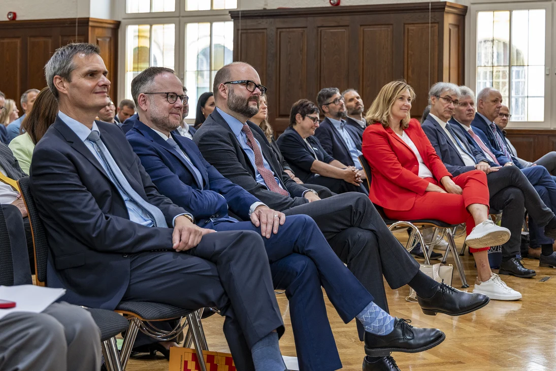 Der Finanzminister und beide Geschäftsführer des SIB lauschen gespannt ihrem Beitrag.