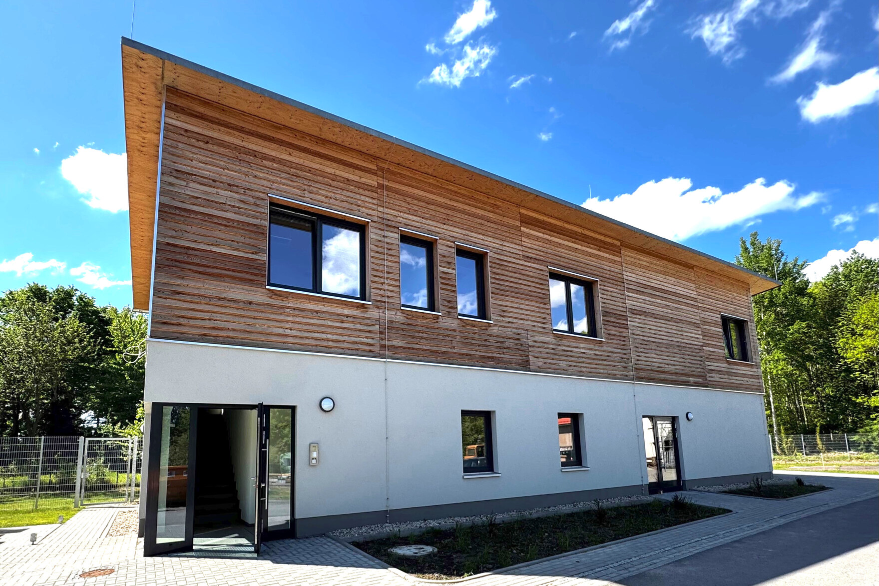 Das Erdgeschoss ist in Massivbauweise ausgeführt, während das Obergeschoss in leichter Holzbauweise errichtet und auch mit Holz verkleidet ist.