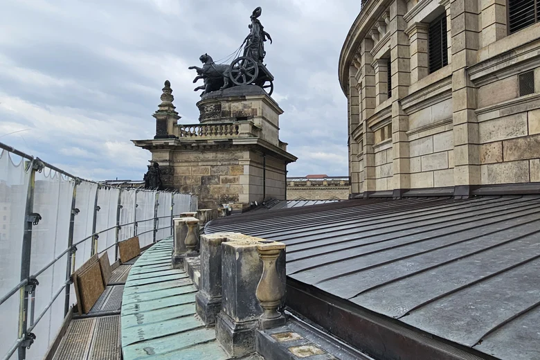 Nebendach mit teilweisen Balustern aus Sandstein und Gerüst an der Dachkante sowie ein Aufbau mit der Quadriga-Statue obendrauf im Hintergrund