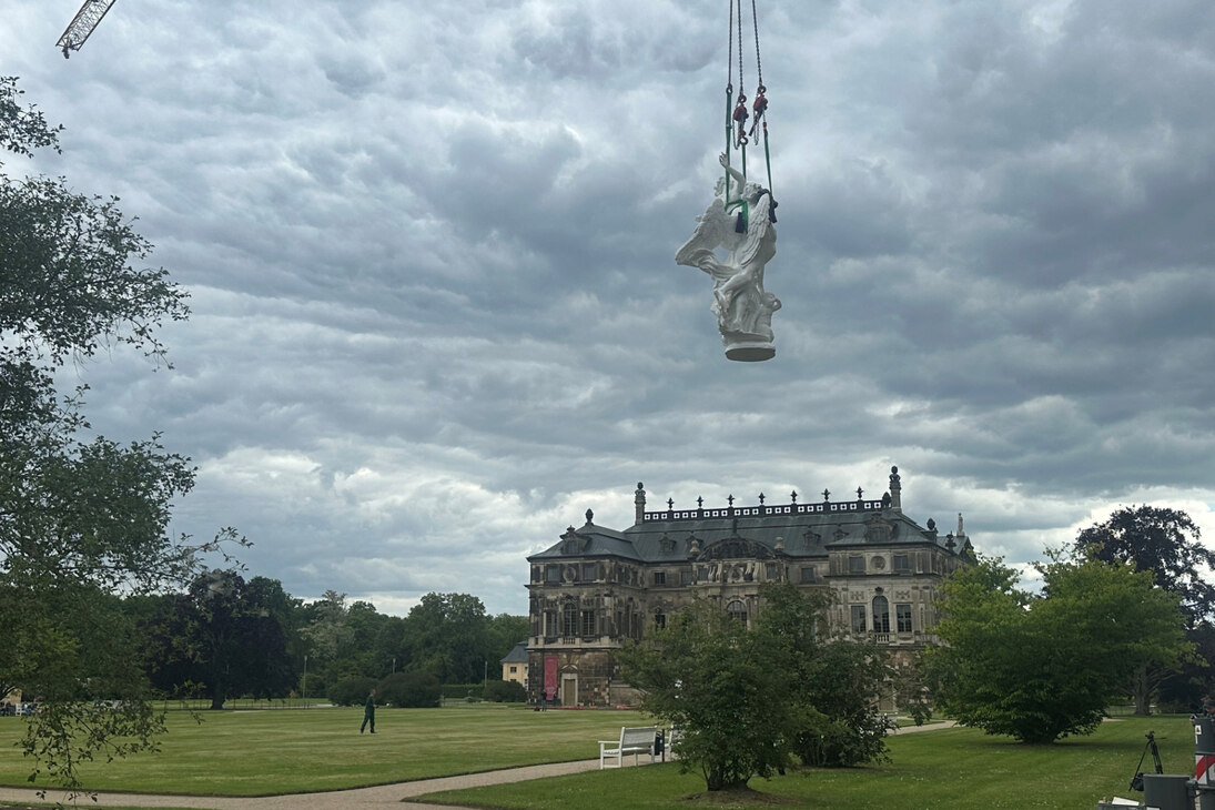 Die Skulptur schwebt mithilfe eines Krans durch die Luft.