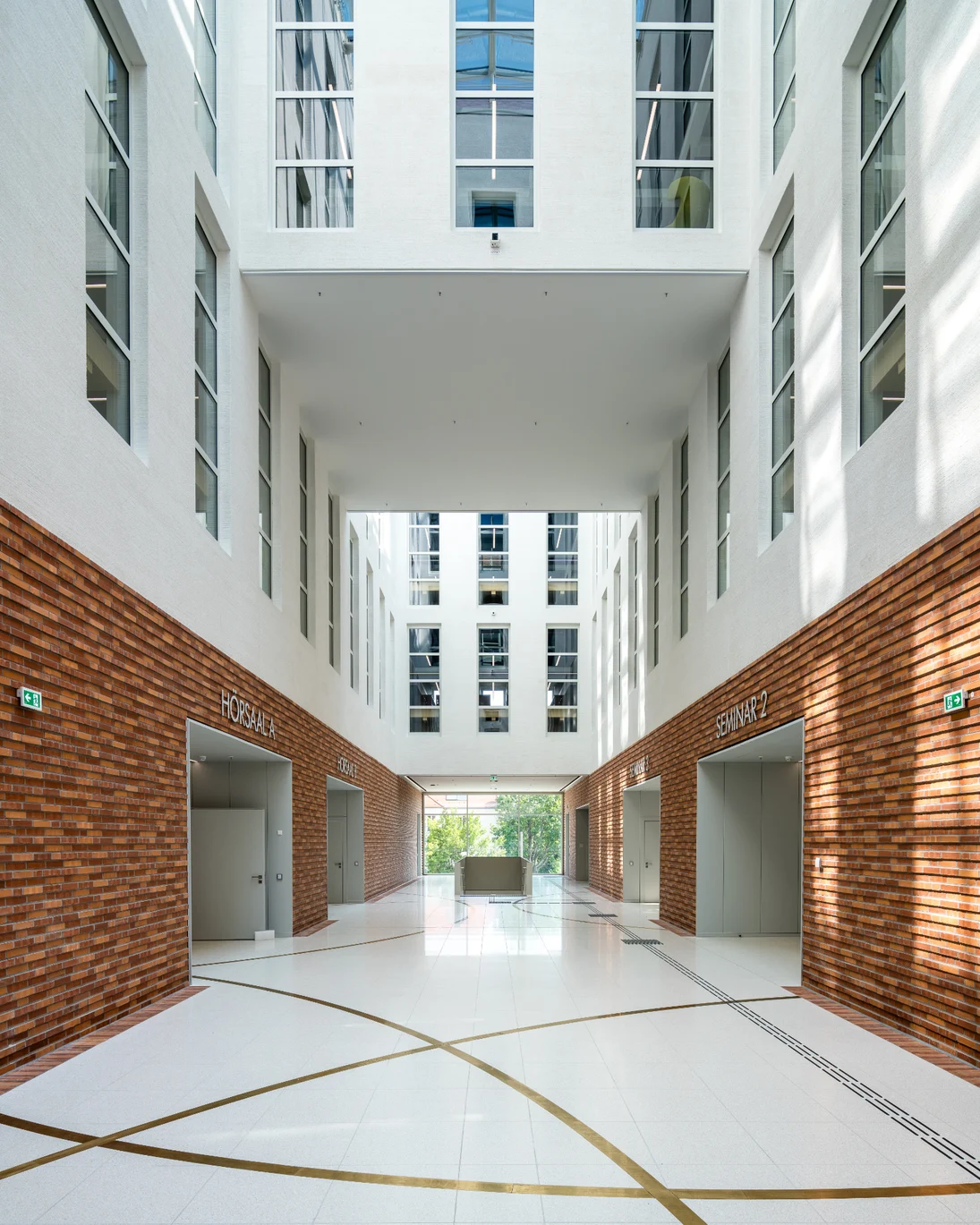 Im Bild ist die sogenannte Innere Stra&szlig;e im Lichthof zu sehen. Die W&auml;nde sind im unteren Bereich mit einer Ziegelfassade verkleidet und der Boden besteht aus hellem Werkstein mit eingelegten Bogensegmenten aus Messing.