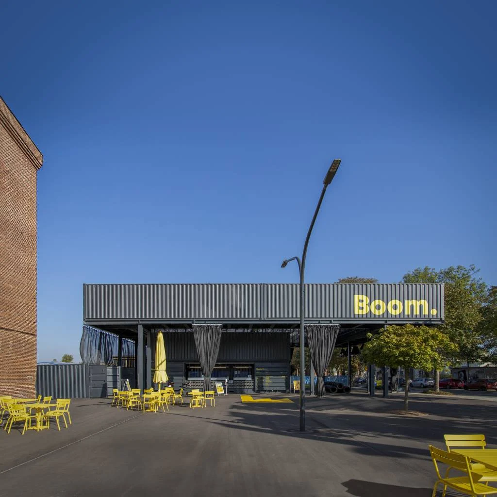 Das tempor&auml;re Eingangsgeb&auml;ude mit Kassenbereich hat eine dunkle Fassade in "Seecontainer-Optik".