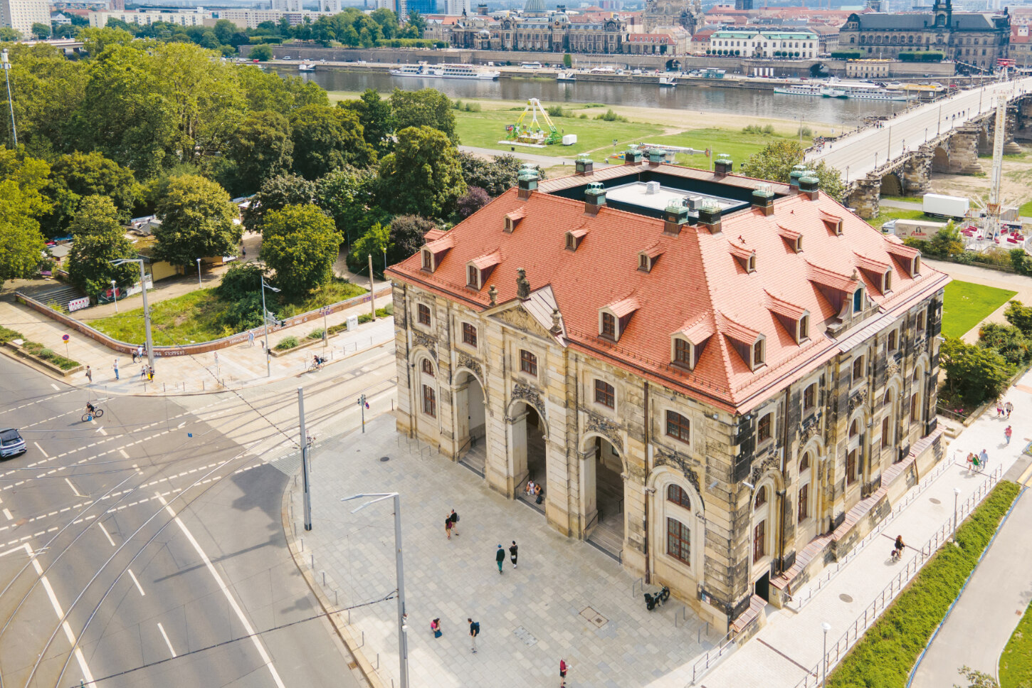 Das Gebäude mit historischer Fassade aus Sandstein und mit roten Dachziegeln bedeckte Dach ist ein markanter Punkt direkt an der Augustusbrücke auf der Neustädter Seite.