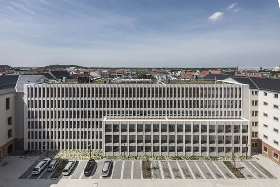 Es ist ein langgestrecktes Gebäude mit viel Fensterfläche und einer hellen Fassade.