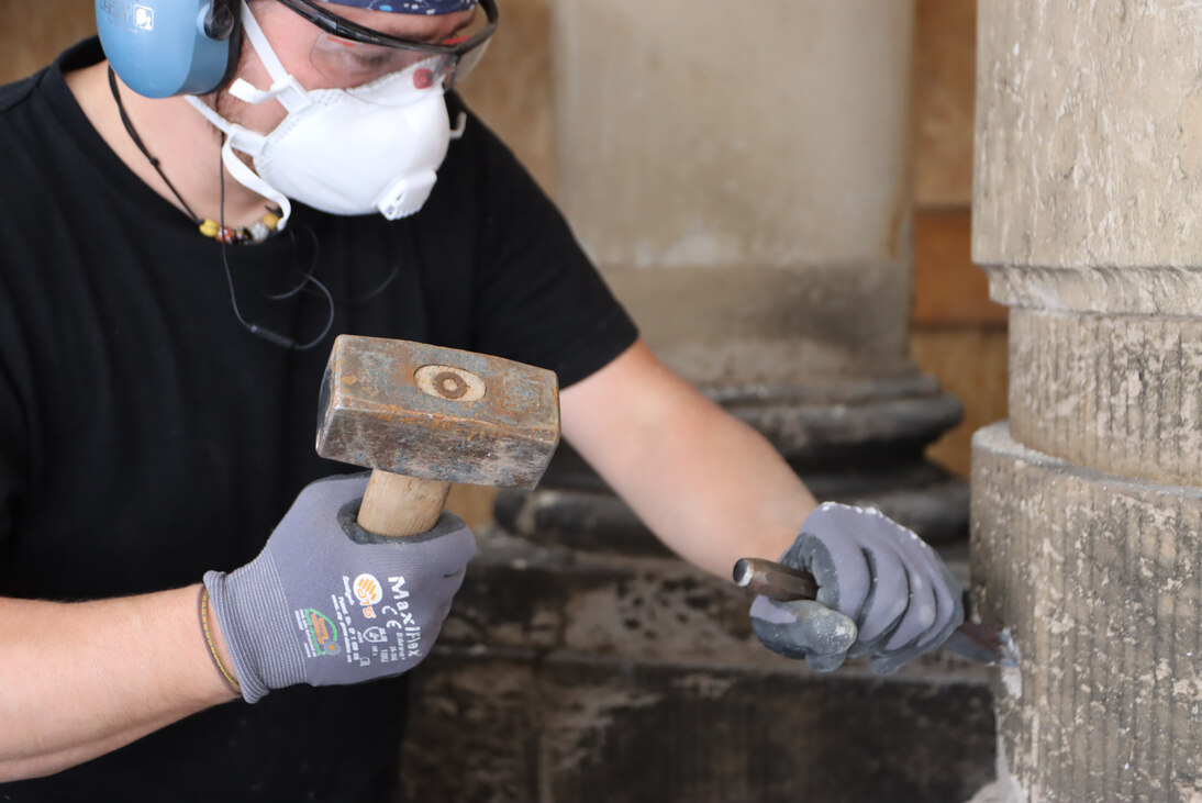 Im Bild erfolgt das klassische Ausarbeiten von schadhaften Sandsteinbereichen mittels Spitzeisen und Fäustel durch einen Steinmetz der Zwingerbauhütte.